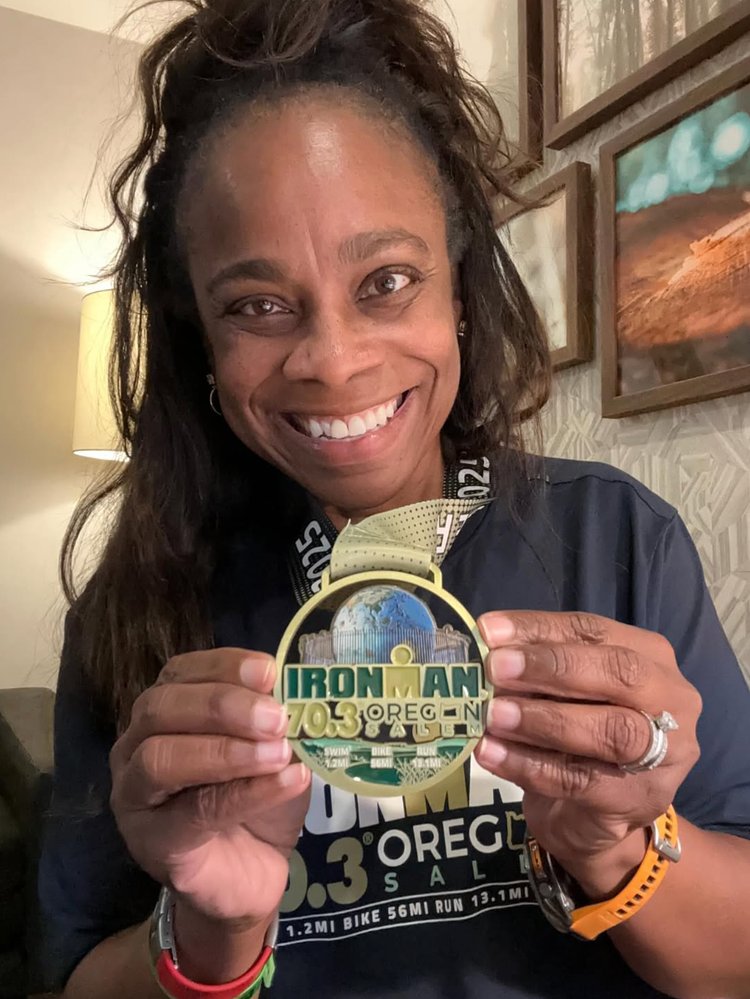 Photo of Novia, one of Coach Adam's athletes, smiling with a medal after an awesome race!