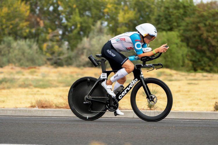 Cyclist maintaining a time trial position on their bike during a race.