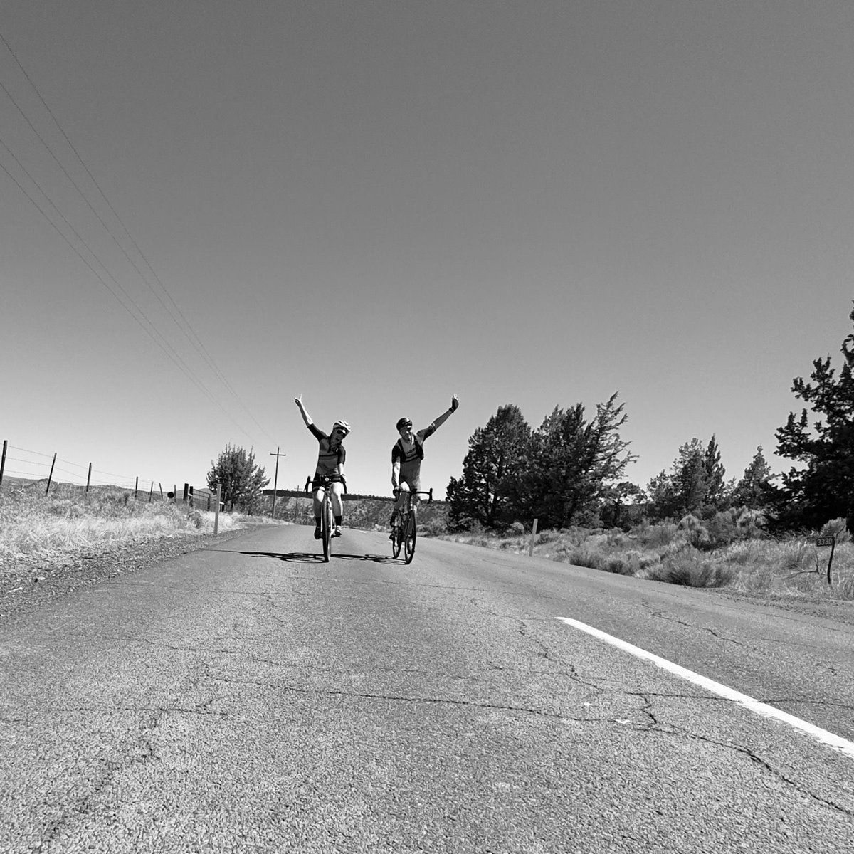 Two happy campers pumping their fists together while cycling.